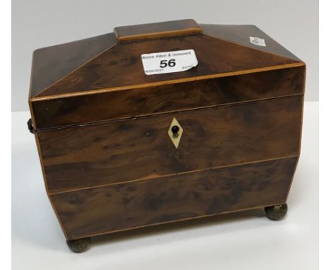 An early 19th Century burr yew veneered and box wood strung two section tea caddy of sarcophagus form with brass ring handles