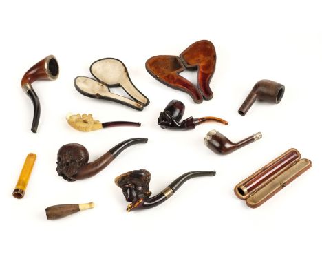 * Pipes. A collection of Victorian and later pipes, including a carved wood skull pipe, 14cm long, another carved a female we