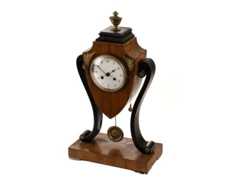 * Clock. A Regency style mantel clock, the satin walnut case of shield form encompassing a circular white enamel dial with bl