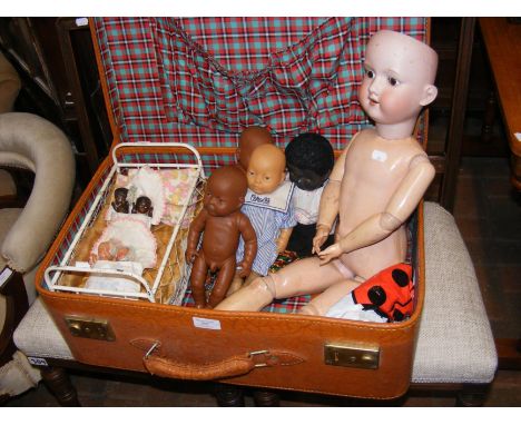 A German Armand Marseille bisque head doll, together with other vintage dolls in an old suitcase 