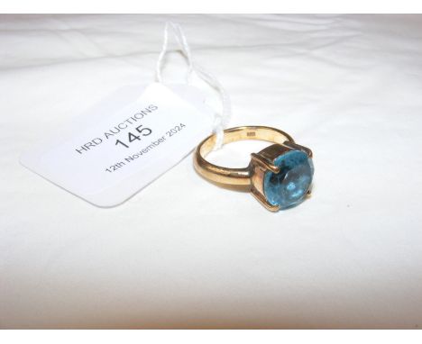 A circular blue stone solitaire ring in 14ct setting