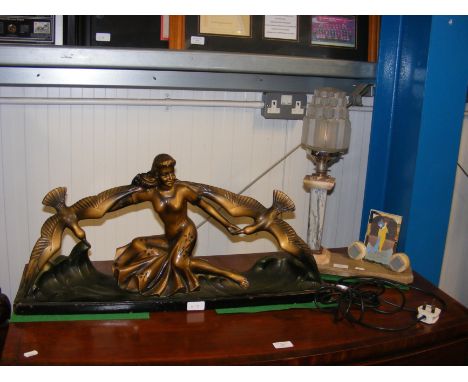 An Art Deco lamp, together with a large Art Deco ornament of woman riding waves  CONDITION REPORT no obvious visible signs of