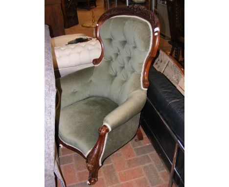 A Victorian button back armchair on cabriole supports