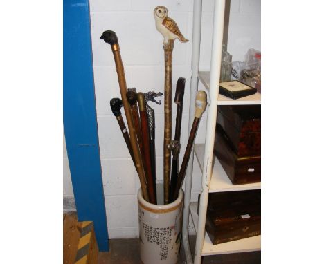 A collection of decorative walking sticks in an oriental umbrella and stick stand 