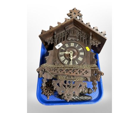 A Black Forest carved oak cuckoo clock with pendulum and weights 