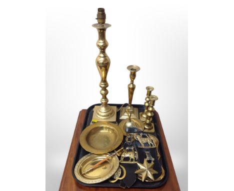 A brass lamp base, pair of brass candlesticks, horse brasses, paper knife in the form of a sword etc 