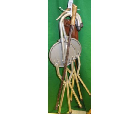 Three various shooting sticks and an antler handled walking stick with fishing fly to to the handle