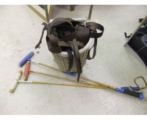 A wicker basket on wheels containing an assortment of various tack, and three polo sticks CONDITION REPORTS Wicker basket has