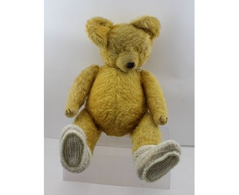 AN EARLY TO MID 20TH CENTURY TEDDY BEAR, having golden mohair plush with stitched paws and nose, articulated limbs and a pron