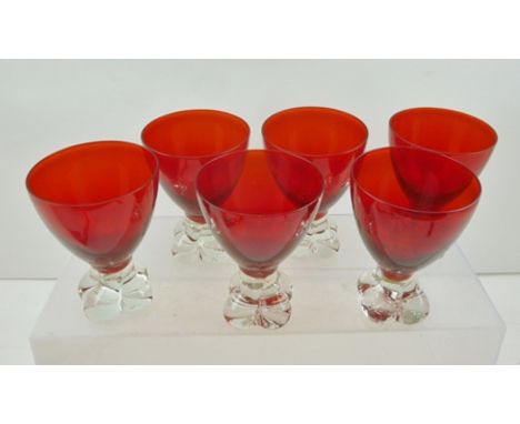 A SET OF SIX MURANO WINE GLASSES, having ruby red bowls on clear quatrefoil lobed bases, circa 1949, 11cm high 