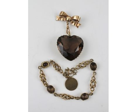 A 9CT GOLD BOW WITH PIN, suspending from it a heart shaped pendant, the facet cut stone, considered to be a smoky quartz, tog