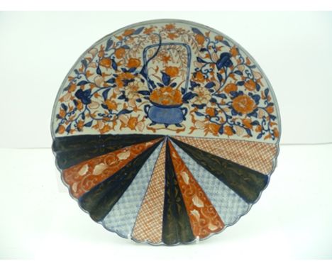 A JAPANESE MEIJI PERIOD CERAMIC PLATE of partially fluted form, painted in the Imari palette with a floral filled censor, sur