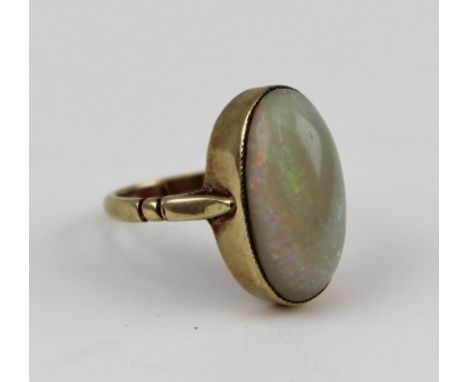 A POLISHED OVAL OPAL SET RING in a rub over 9ct gold mount, ring size K and half 