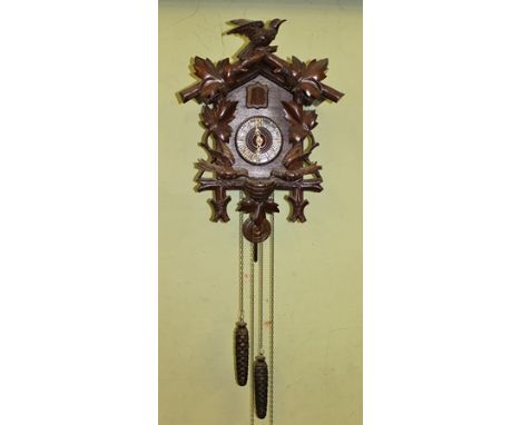 A BLACK FOREST WALL MOUNTING CUCKOO CLOCK, the carved wooden case with automaton movement, Gothic numerals, circa 1900, 50cm 