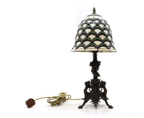 A bronze table lamp, 20th century, in the style of Ferdinand Barbedienne, terminating in three paw feet, with a Tiffany style