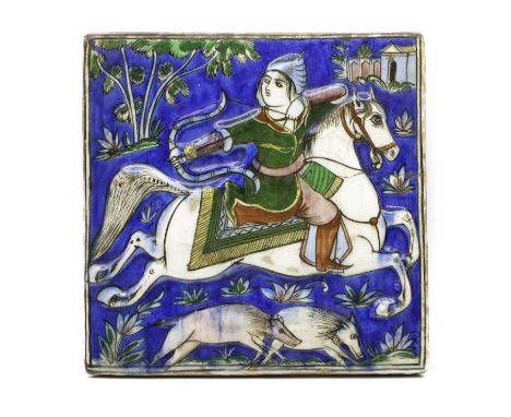 A Qajar polychrome moulded tile,  c.1900, in low relief with a mounted archer hunting boar,  21 x 21cmProvenance: The Collect