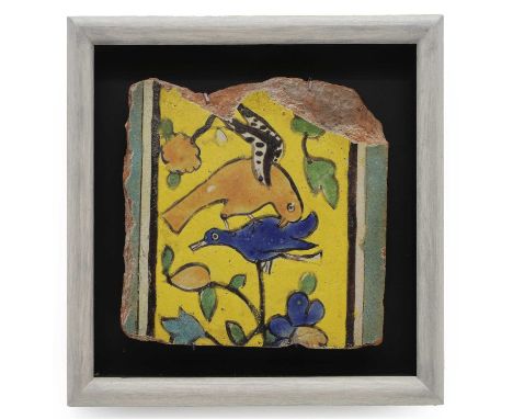 A Mughal cureda-seca pottery border tile,  late 17th century, with birds on a branch, with a polychrome glaze, on a yellow gr