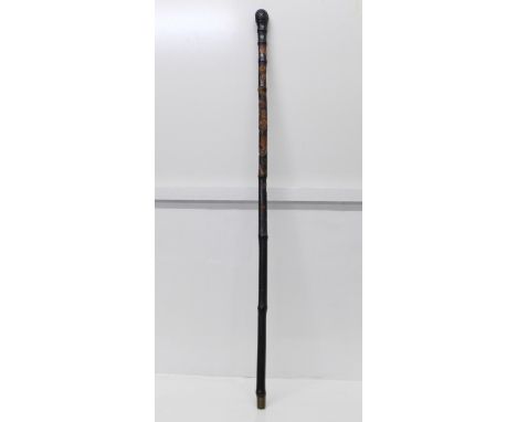 A Japanese ebonised bamboo walking cane, root finial, with finely carved decoration of two snakes, a lizard and flowers, four