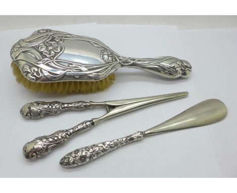 An Art Nouveau silver backed hair brush, silver handled glove stretchers and a similar shoe horn 