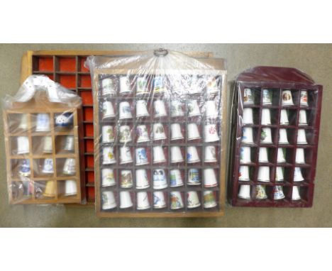 Eighty-two ceramic thimbles and four display racks 