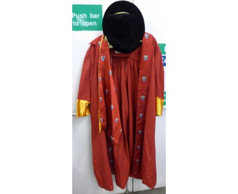A crimson graduation robe and sash with University crest with black hat, maker's label Ede &amp; Ravenscroft Ltd., Chancery L