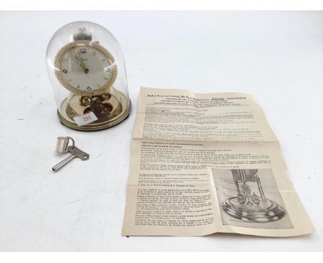 A kundo 400 day mantle clock in glass dome 15cmH 