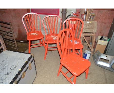 A set of four red painted stick back chairs