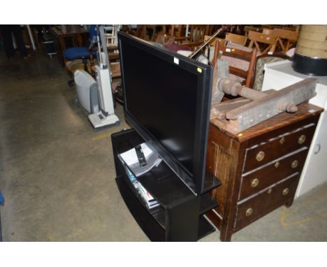 A Sony Bravia flat screen television with remote control and instruction manual; together with a glass TV stand and a quantit