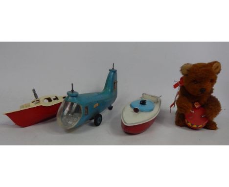 A collection of clockwork items, to include two Sutcliffe speedboats, a drum playing bear and a plastic air sea rescue helico