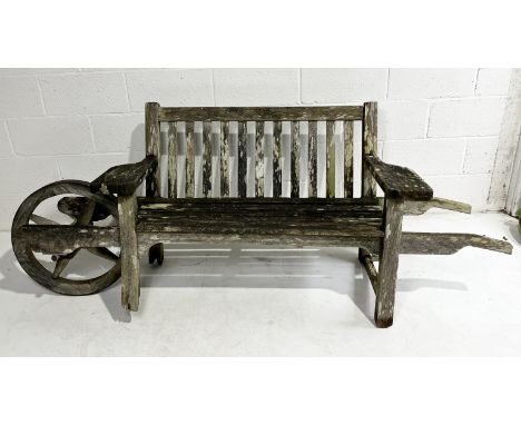 A weathered Andrew Crace wheelbarrow bench with slatted back A/F 
