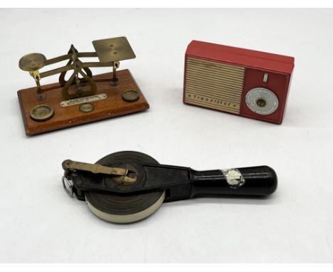 An antique Chesterman well gauge along with a vintage Ever Ready transistor radio and postal scales
