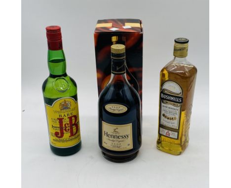 A boxed bottle of Hennessy V.S.O.P Privilege Cognac, along with a bottle of Bushmills Irish Whiskey and J&B Old Scotch Whiske