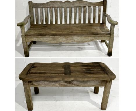 A weathered garden bench and matching table with oak leaf design to front