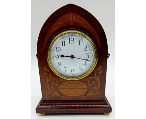 A Victorian mahogany arch shaped mantle clock, with shell patera inlay, on brass bun feet.
