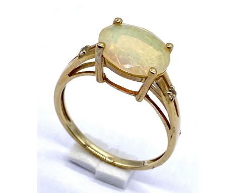 A 10K/975 gold Ethiopean opal solitaire ring set with a single white stone to each shoulder, size O - 2.1g total weight. 