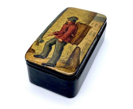 An antique paper mâché snuff box, the lid depicting a peddler