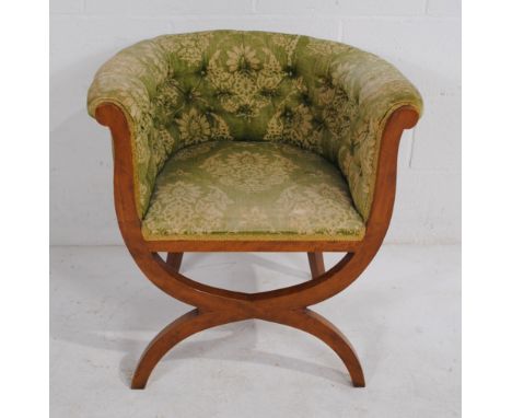 An antique upholstered X framed tub chair, with button-back detailing