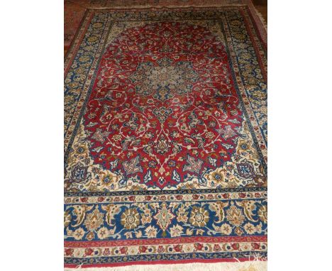 A Persian red ground Isfahan Najafabad carpet, having central medallion on a scrolling foliate ground, multi-bordered and fri