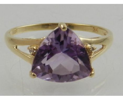 A 9 carat yellow gold and trillion cut amethyst ring, each shoulder set with a small diamond accent. 