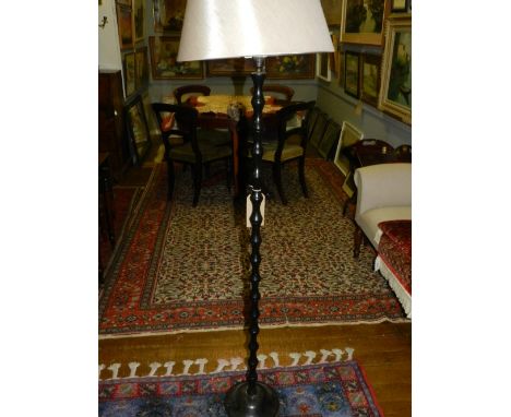 A black painted metal standard lamp, having turned column support, with cream coloured shade. H: 159cm  