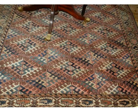 A red ground Turkoman carpet, having multi diamond shaped medallions to centre within many borders, fringed, L.315cm, W.170cm