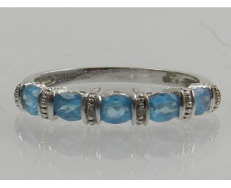 A 9 carat white gold and blue topaz ring, set five oval cut topaz.