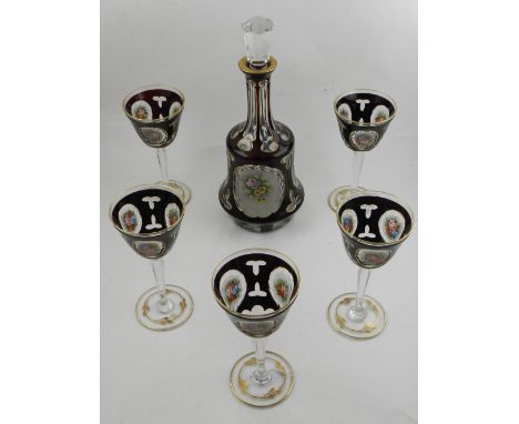 A Bohemian Ruby flash glass decanter with stopper and five wine glasses, highlighted in gilt, having vignettes decorated with