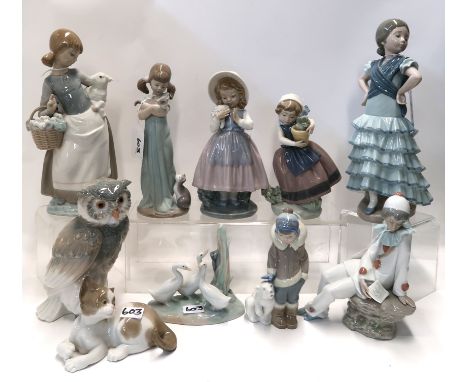 A collection of Lladro figures including a flamenco dancer girl, girl with kitten, Eskimo and polar bear, cat, girl and pot p