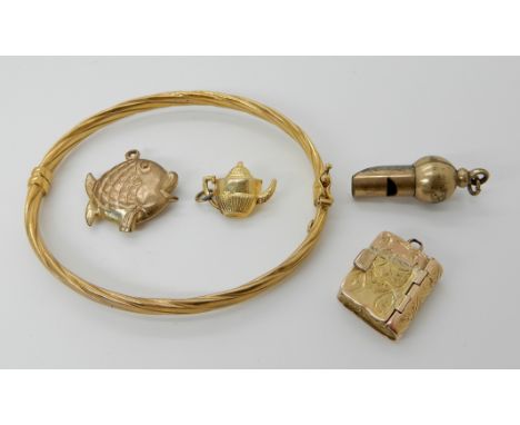 A 9ct bangle, together with two 9ct charms, combined weight 6.6gms and a yellow metal book shaped locket and gold plated whis