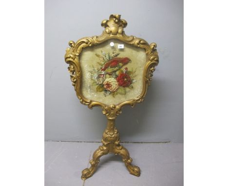 A VICTORIAN CARVED GILTWOOD FIRESCREEN of cartouche outline the needlework panel depicting exotic birds and flowerheads raise