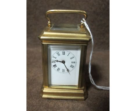 A MINIATURE FRENCH BRASS CARRIAGE CLOCK with enamel dial and Roman numerals