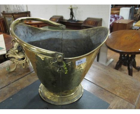A BRASS SWING HANDLE COAL HELMET raised on a circular spreading foot