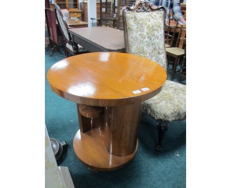 A GOOD ART DECO STYLE WALNUT TABLE of circular outline the shaped moulded top above a carved column with moulded shelves rais