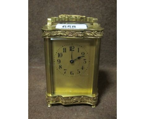 A FRENCH BRASS CARRIAGE CLOCK the engraved case with foliate scrolled handle on turned legs